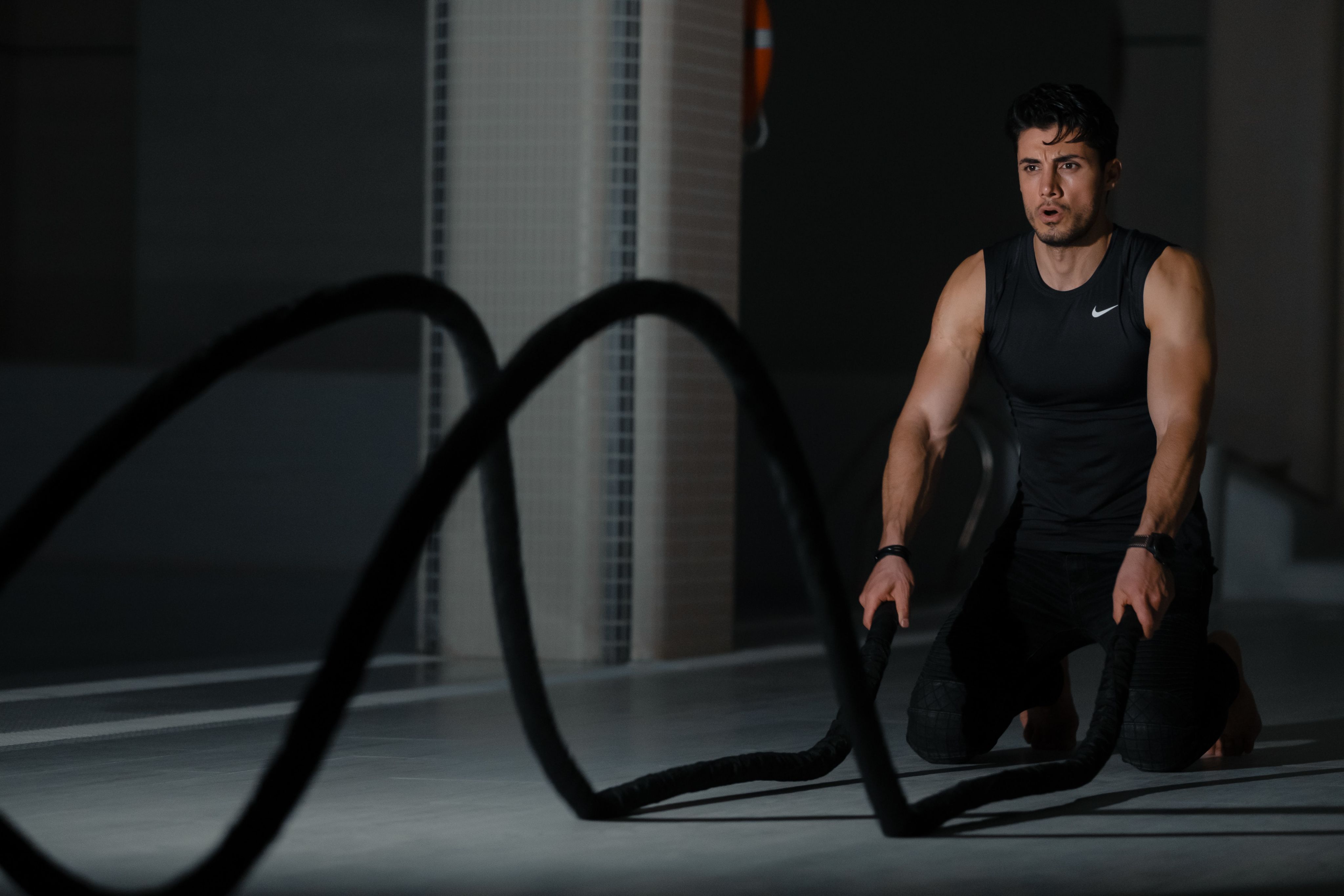 woman in black tank top and black pants sitting on black exercise equipment